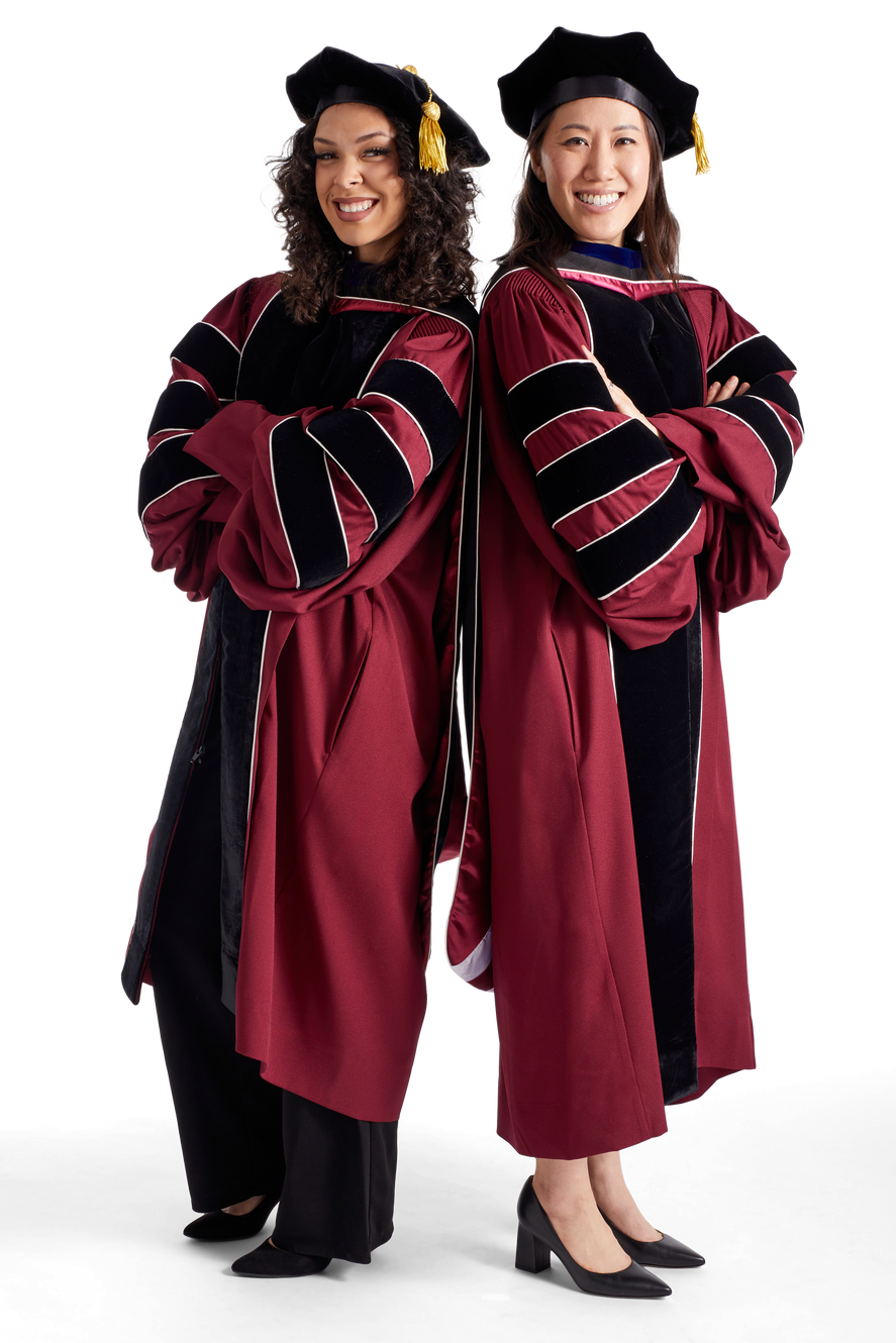 Two people wearing burgundy doctoral regalia